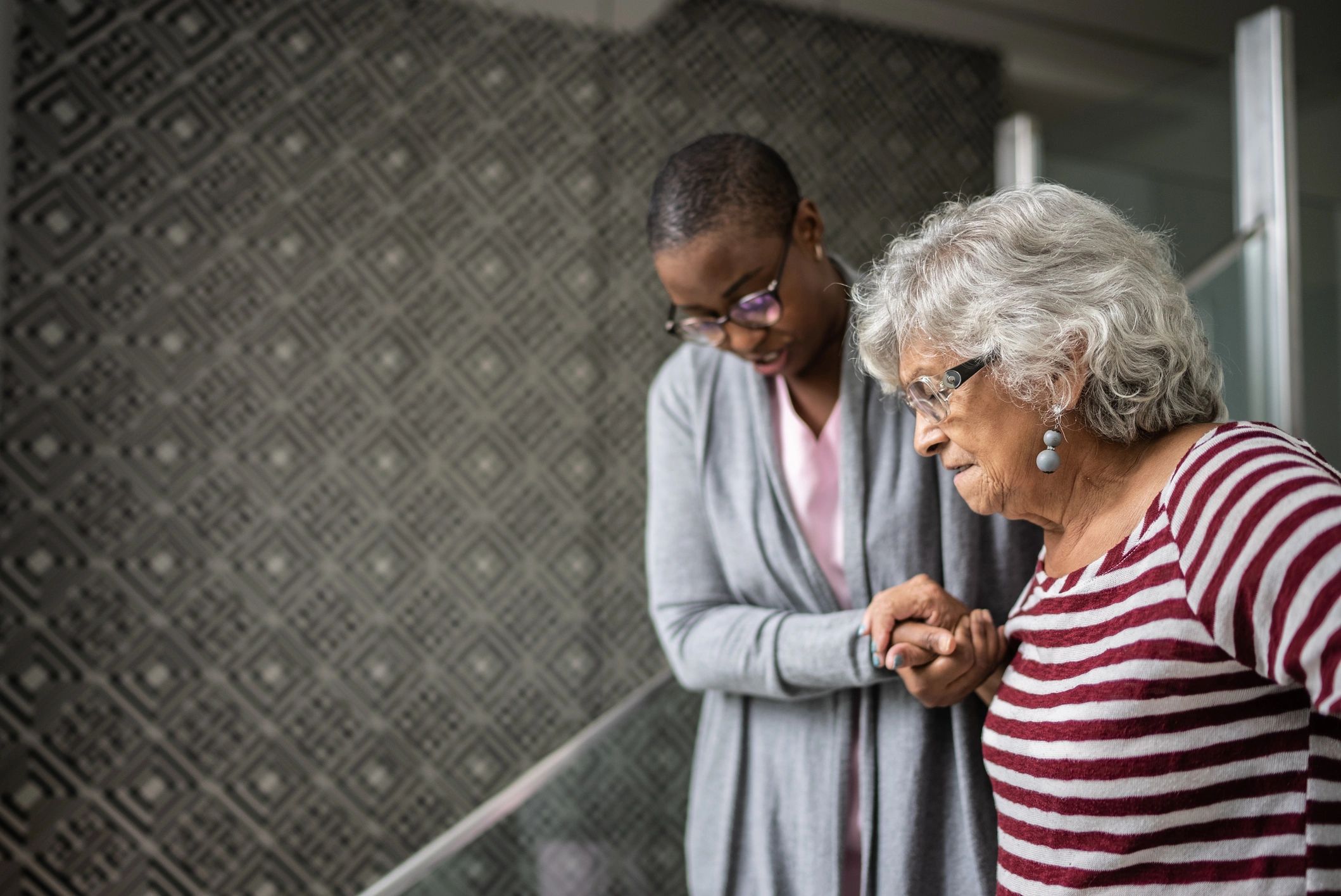 Caregiver assisting a senior with mobility support while out
