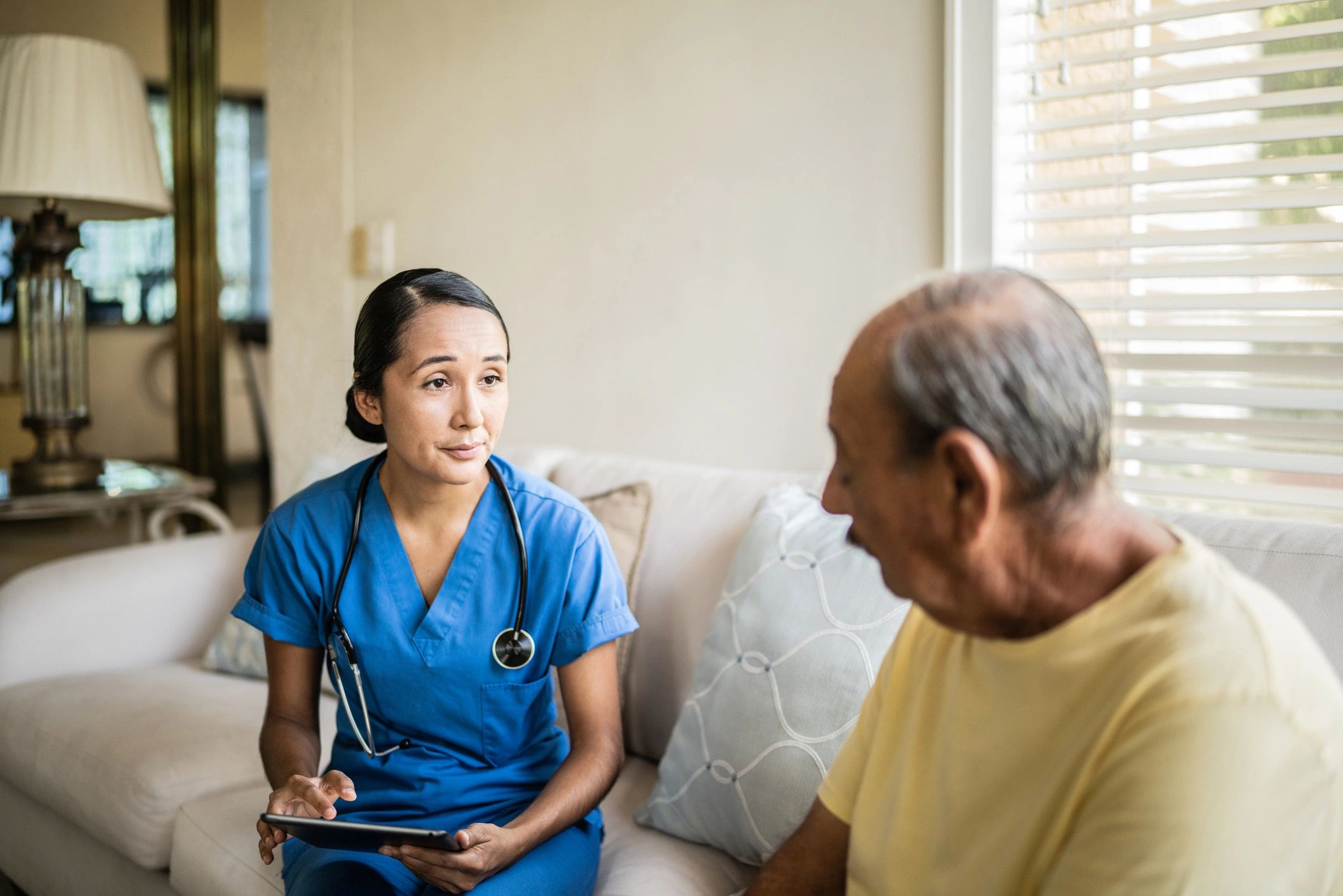 Nurse consulting with a senior using a tablet