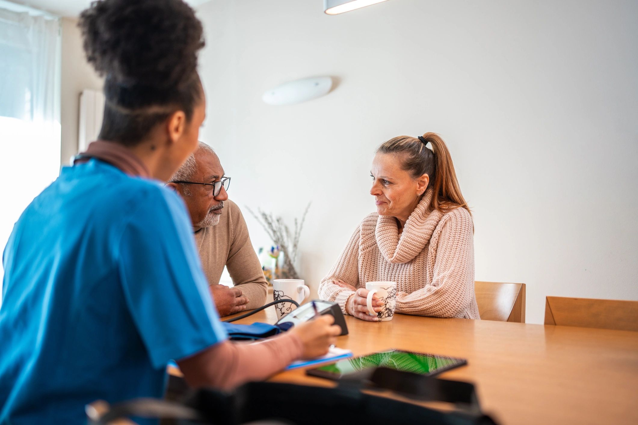 Nurse consulting with an older couple indoors