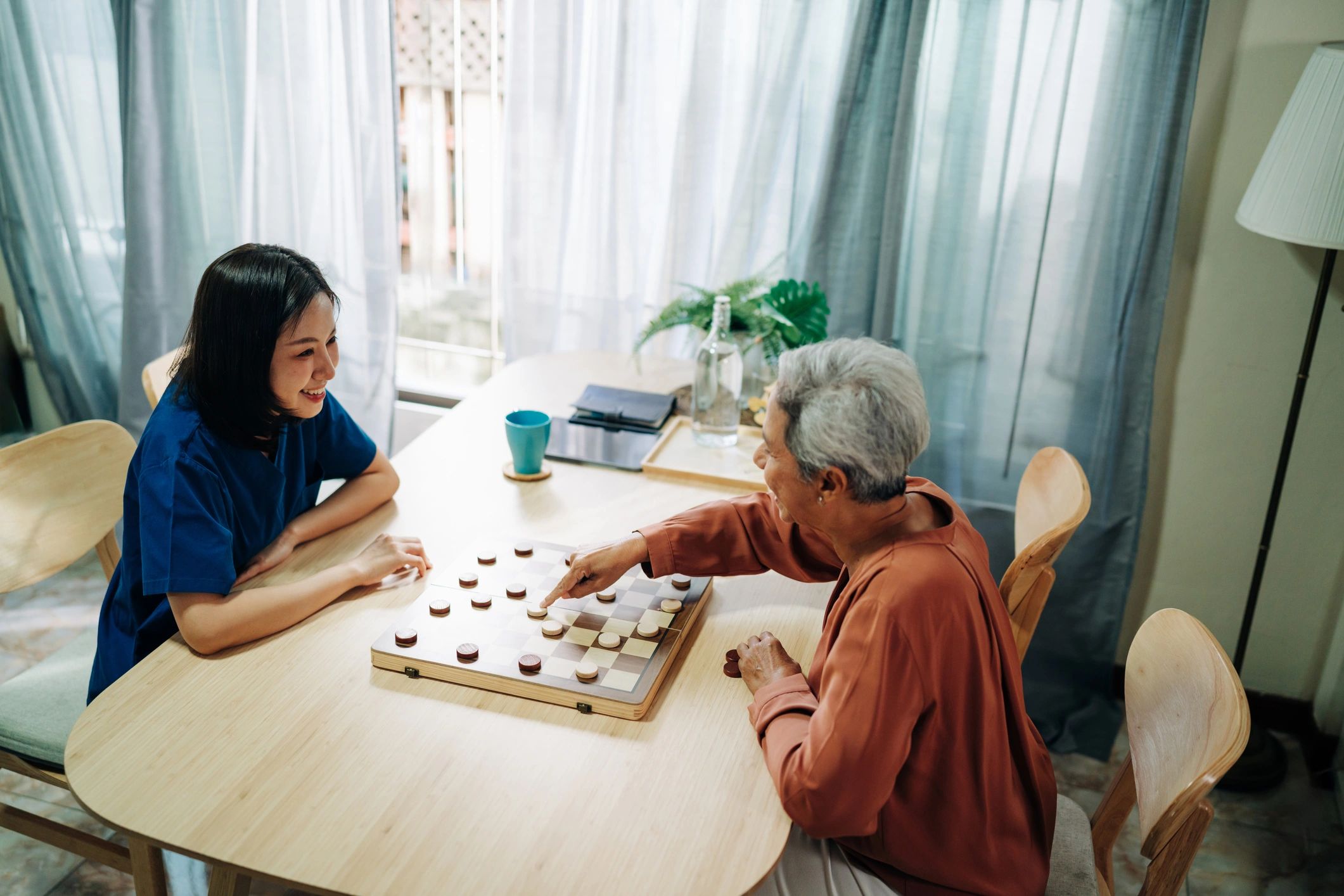 Caregiver spending time with a senior at home during companionship care